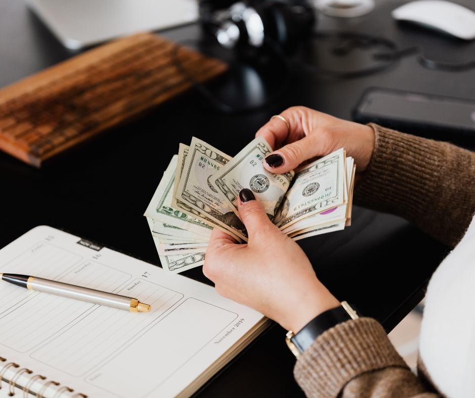 woman counting money with a notepad nearby