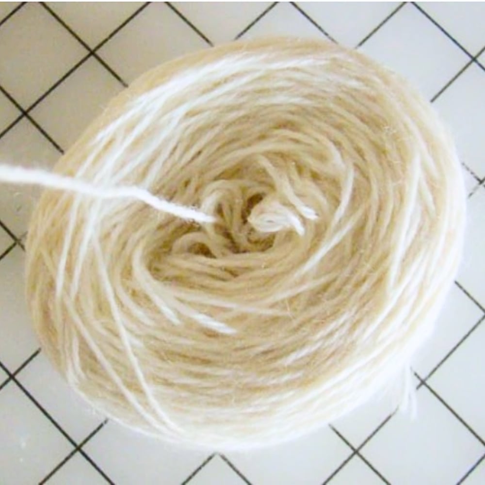 white yarn wound into a cake on a sewing table background