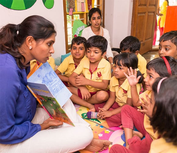 Children listen to their teacher as she tells them interesting stories to develop their learning skills.