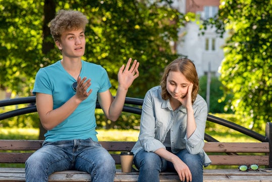 guy talking to a girl on a bench