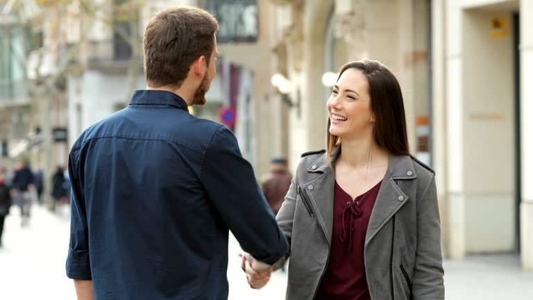 Man approaching a woman smiling