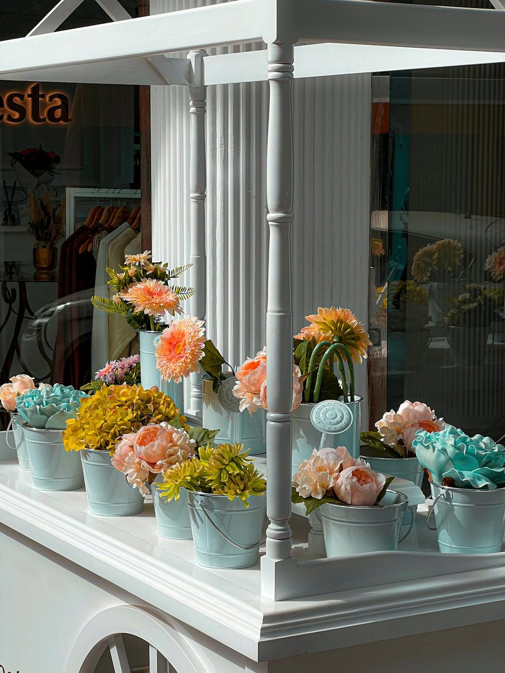 A variety of colorful flowers blooming in terracotta pots on a balcony.