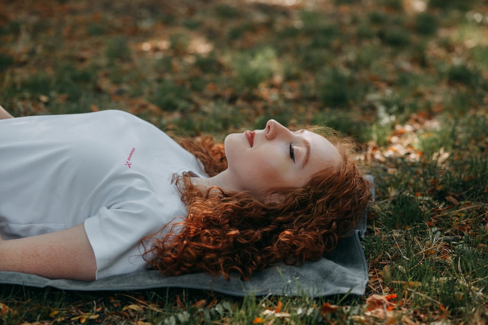 Young woman resting on the gras in nature during the day