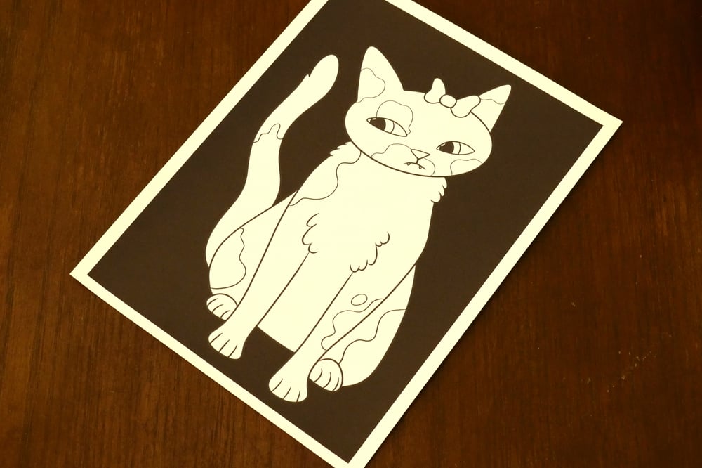 A black and white coloring sheet showing a cat with a bow on its head.
