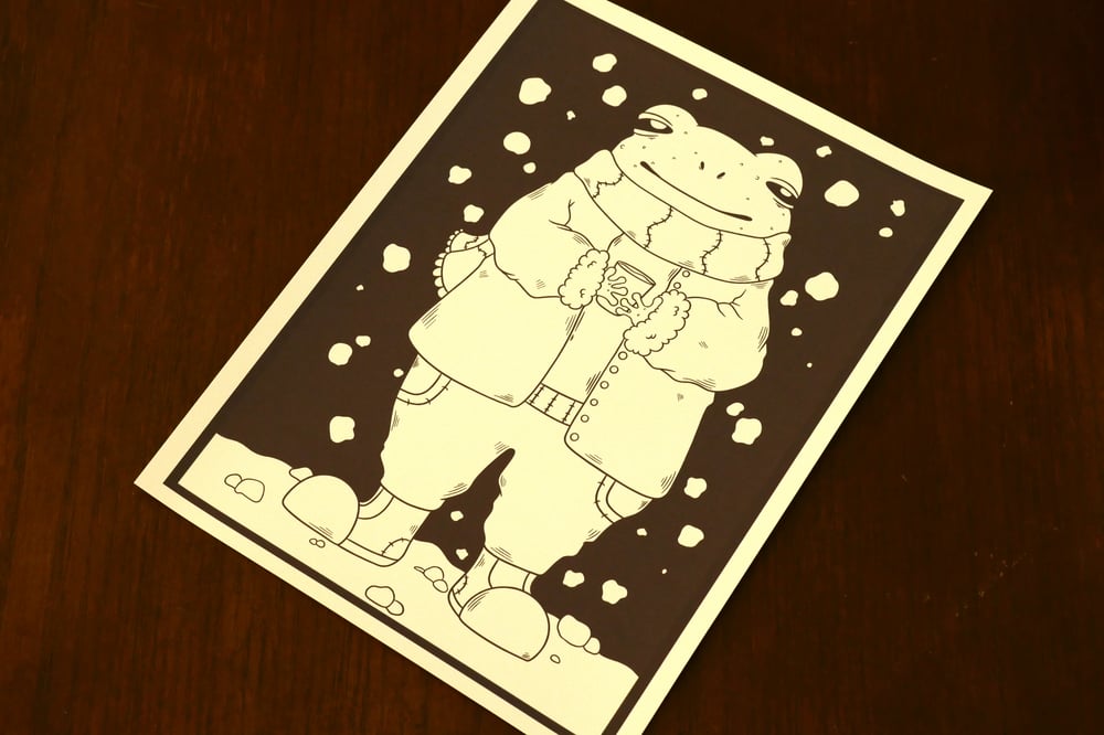 A black and white coloring sheet showing a frog outside during winter.