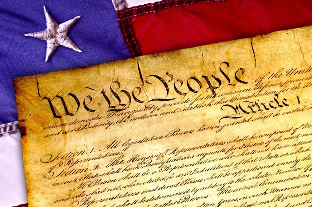 stock image showing a collage of the USA flag transposed with the top of the USA Constitution, "We the people" clearly visible