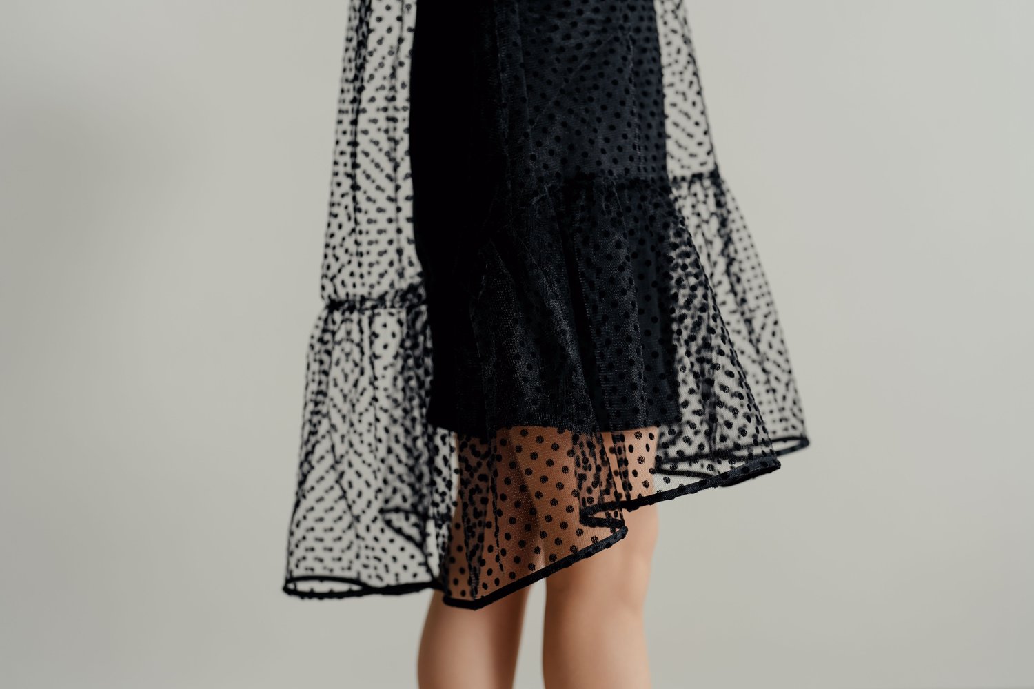 Gros plan du volant et de la jupe en tulle superposé de la Robe Sparkle noire à pois, MUNA Patterns