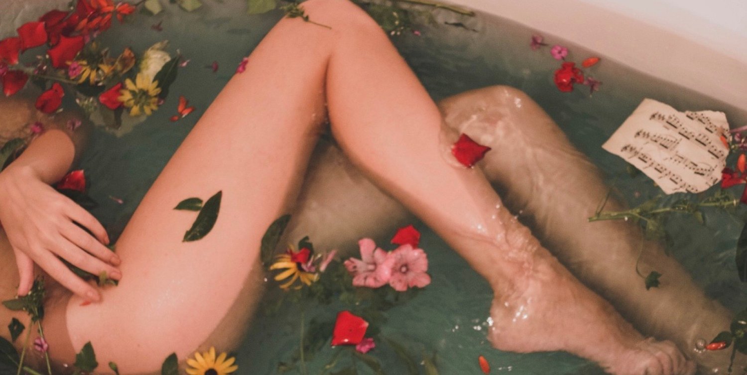 women in bathtub with roses