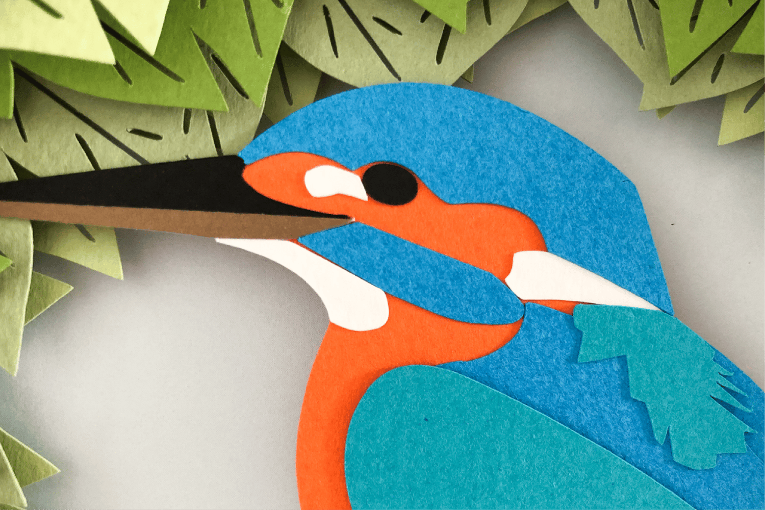 Close up of a kingfisher paper cut in a shadow box
