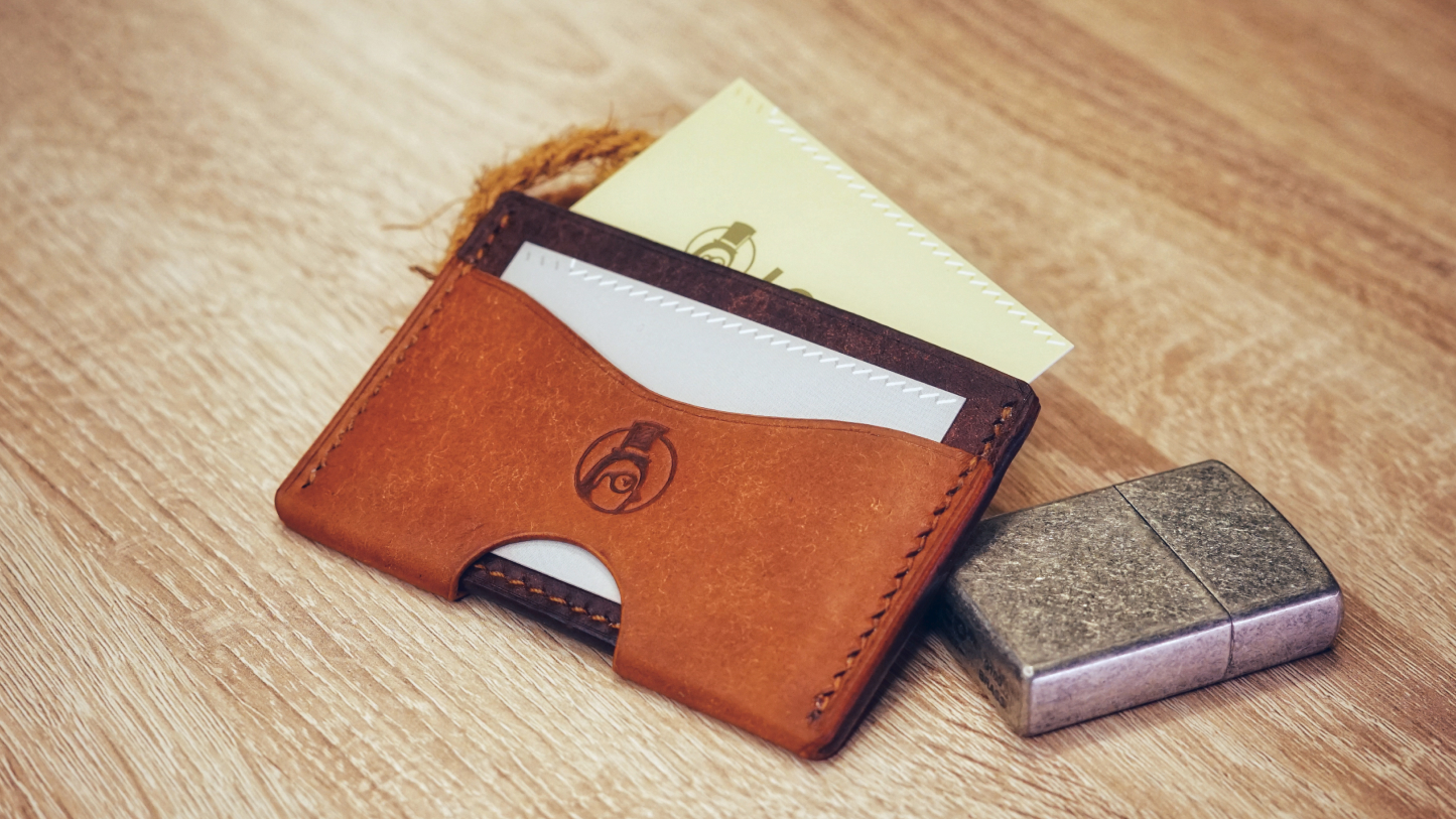 A minimalist cardholder looking like 2 wraps hugging, with card on the middle and cash on the flap pocket