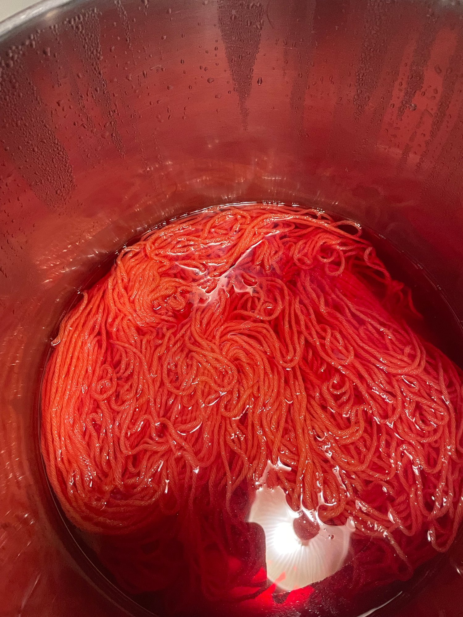 Yarn in the dye bath - currently a hot orange color