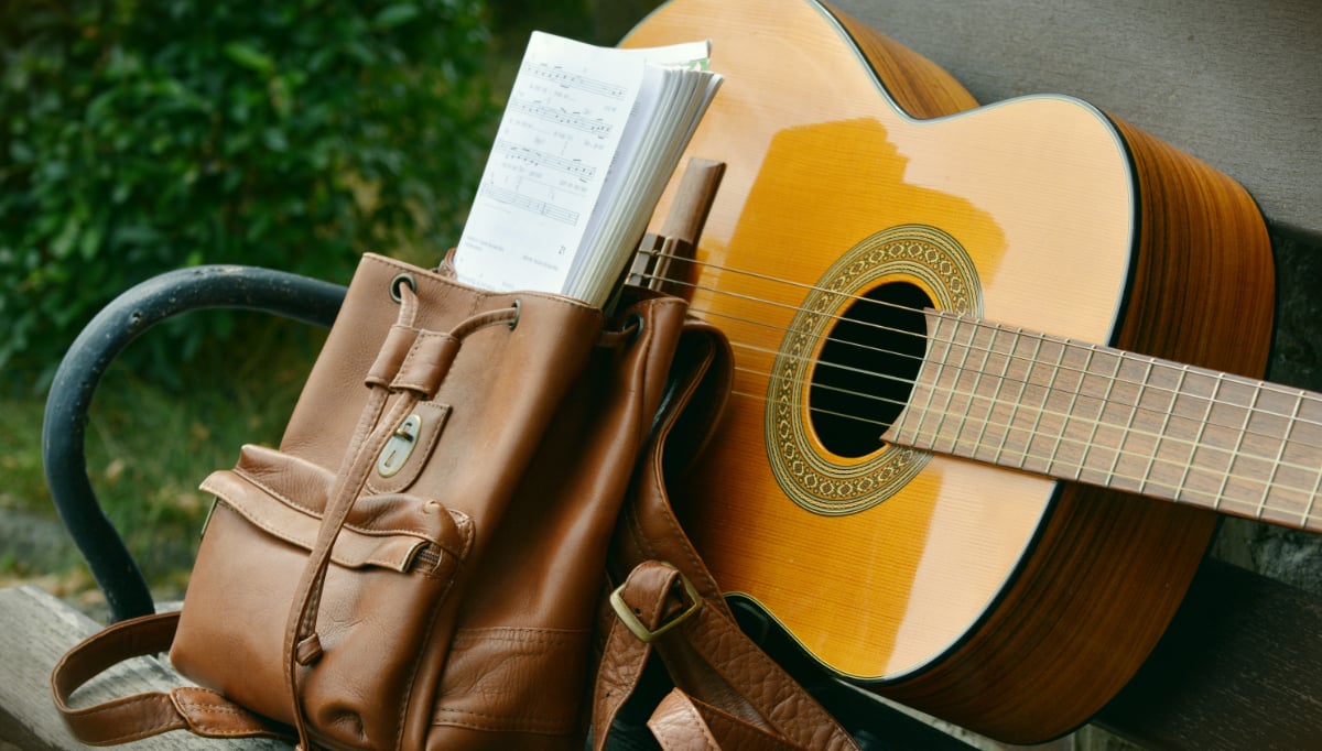 guitar and brief case on bench