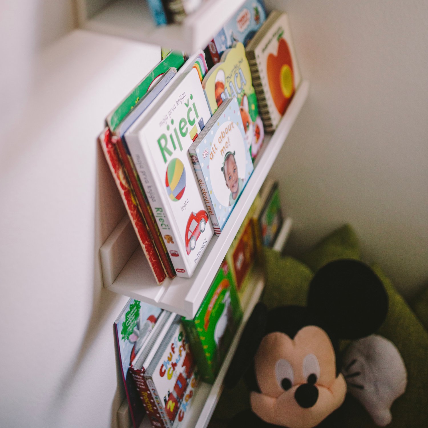 Dvogodišnji dječak traži slikovnicu na polici