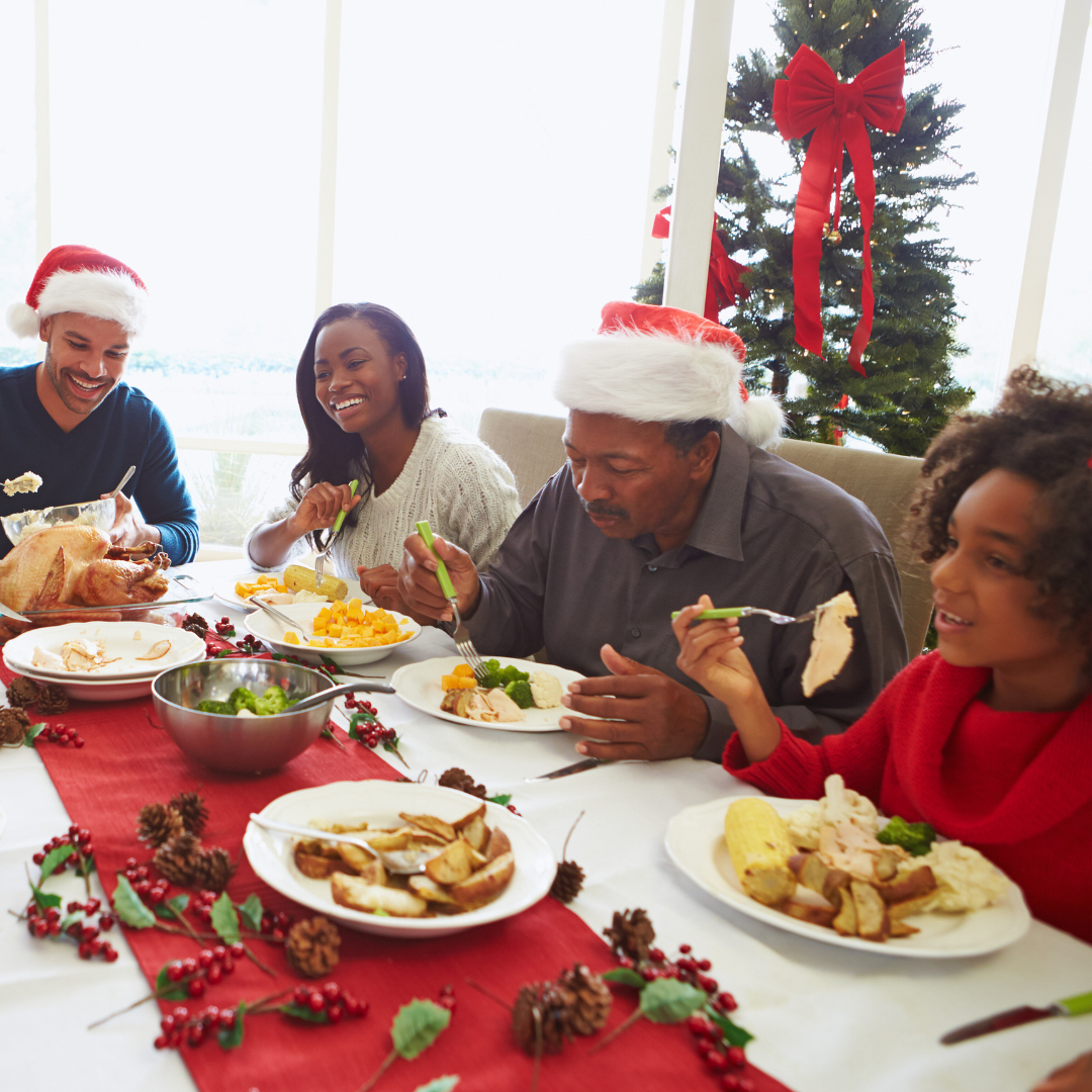 Friends and family enjoying a festive holiday meal around a beautifully set table, embodying mindful eating and balanced healthy choices during the festive season.