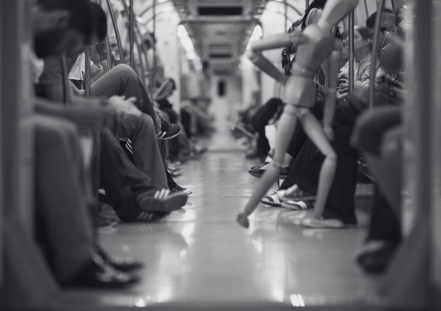 Vagón de metro en blanco y negro, maniquí de madera erguido