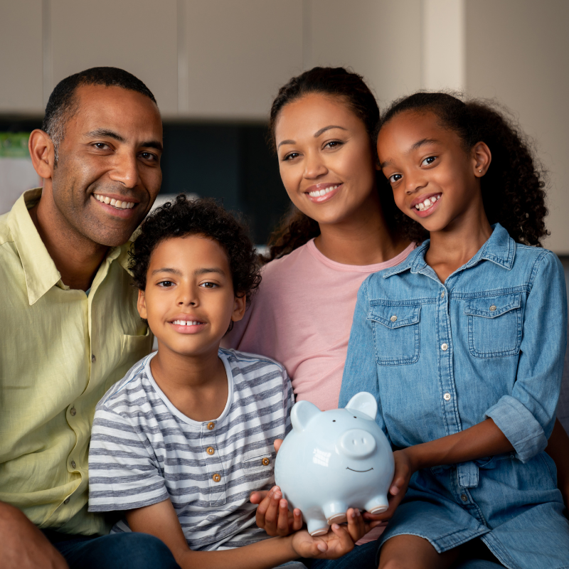 Black family & Finance- holding a piggybank and smiling for TES Virtual Learning Hub athttps://www.trendyeducationalservices.com