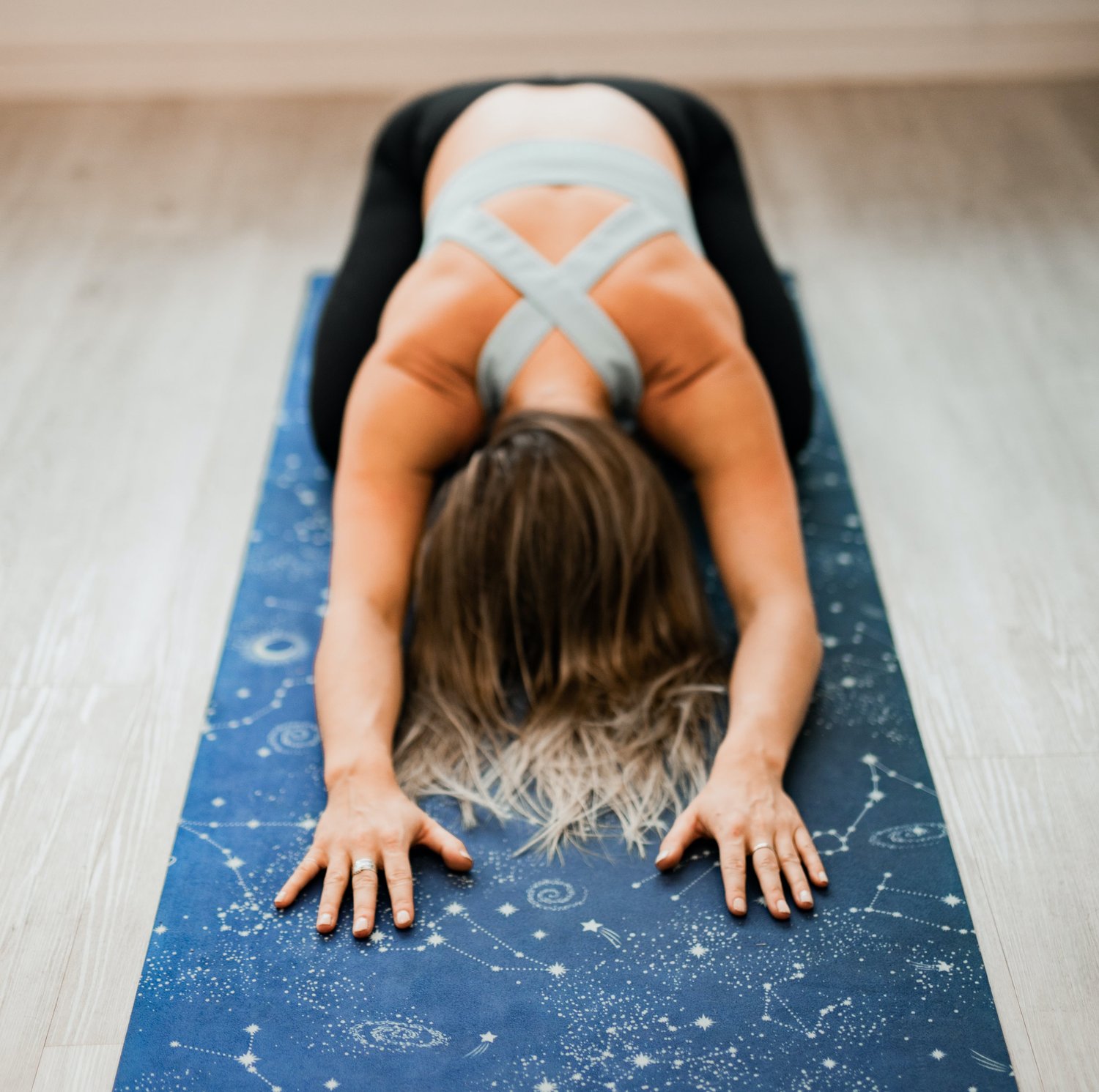 woman in childs pose on yoga mat