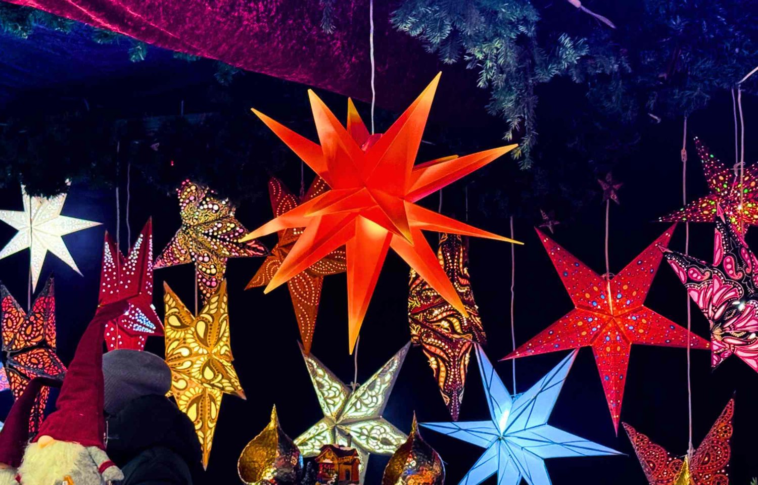 In the heart of Hamburg, Christmas unfolds with a magic that transcends the ordinary, a unique enchantment that finds its manifestation in the "Weißerzauber" Christmas market at Jungfernstieg. Here, the holiday spirit takes on a special form, turning this market into not just a destination but a theatrical stage where festive anticipation dances hand in hand with regional craftsmanship, creating a paradise for lovers of mulled wine and seekers of exquisite Christmas gifts.  As the city prepares for the pre-Christmas period, Jungfernstieg undergoes a captivating metamorphosis. It transforms into a mesmerizing sea of lights and colors, a kaleidoscope of festive hues that captures the imagination of both locals and visitors alike. Each step along the cobblestone pathways is a journey into a world where the air is filled with the scents of seasonal delights, and the surroundings come alive with the sound of joyous laughter and shared moments.  The "Weißerzauber" Christmas market stands as a beacon of holiday cheer, beckoning all to experience its unique atmosphere. To visit is to step into the Christmas world of Hamburg, a world where the magic of the season is not just observed but fully embraced. The market becomes a canvas, painted with the charm and warmth that define the city's Christmas spirit.  Against this festive backdrop, adorned with the best Hamburg Christmas decorations, the market showcases the artistry and creativity of regional craftsmen. Each stall is a testament to the pride and skill of the local community, offering a delightful array of beautifully crafted ornaments, trinkets, and decor that embody the spirit of the season. To wander through this market is to embark on a journey through the heart of Hamburg's holiday identity.  The shores of Jungfernstieg, framed by the elegant white design of the market, create a picturesque setting that adds to the timeless allure. The tranquil waters of the Binnenalster mirror the festive lights, enhancing the magic that permeates the surroundings. It is a scene that invites visitors to linger, to savor the special atmosphere that distinguishes this Christmas market as one of the best in Hamburg.  For those with a penchant for the finer indulgences of the season, the market is a haven for lovers of mulled wine—a place where the rich, aromatic notes of this seasonal delight mingle with the crisp winter air. It is a sensory experience, a moment of warmth that adds another layer to the overall enchantment of the Christmas market.  In essence, the "Weißerzauber" Christmas market at Jungfernstieg is more than a collection of stalls and lights; it is a celebration of the best Hamburg Christmas has to offer. It is a testament to the city's ability to infuse the holiday season with unparalleled charm, creating a space where tradition, craftsmanship, and the joy of the season converge in a magical dance. To visit is not just worthwhile; it is an invitation to immerse oneself in the very essence of Christmas in Hamburg.