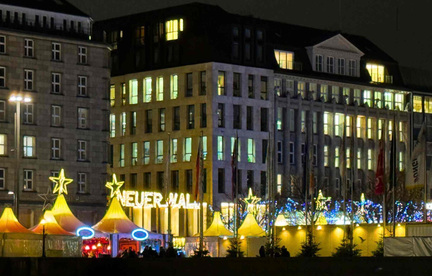 In the heart of Hamburg, the Christmas Market on Jungfernstieg unfolds as a timeless spectacle, capturing the essence of the season with its most beautiful Hamburg Christmas offerings. Opening its gates from 11 am to 10 pm, with extended hours until 11 pm on Fridays and Saturdays, the market becomes a haven where tradition meets modernity, and the spirit of Christmas transforms the cityscape into a luminous wonderland.  Jungfernstieg, adorned with glittering lights, an array of craft stalls, and a historic Ferris wheel, graces the shores of the Binnenalster. This iconic location becomes a magical tableau where every detail contributes to the allure of the most beautiful Hamburg Xmas decor. As visitors meander through the market, they are greeted by a symphony of festive delights—mulled wine, culinary treasures, and a breathtaking view of the Christmas-decorated Alstertanne tree in the middle of the lake.  The Jungfernstieg Christmas Market is not merely a gathering of stalls; it is an immersive experience, a celebration where the past and present converge to create an ambiance that transcends time. The glittering lights that adorn the market are a testament to the city's commitment to providing the most beautiful Hamburg Xmas decoration, a visual feast that ignites the senses.  An insider tip for visitors is to take a moment to admire the fairytale boats on the Alster, which dock right at the Christmas market on Jungfernstieg. These whimsical vessels add an extra layer of enchantment to the festivities, offering a unique perspective on the holiday magic that permeates the surroundings.  As the day transitions into night, the market becomes a symphony of lights that dances along the Binnenalster. The historic Ferris wheel stands as a sentinel of joy, inviting visitors to ascend to new heights and revel in the panoramic views of the city adorned in its most beautiful Hamburg Christmas decoration.  The Jungfernstieg Christmas Market is a testament to the city's commitment to providing an immersive and magical experience for all who enter its gates. It is a celebration where the most beautiful Hamburg Xmas decor becomes a canvas for shared moments, laughter, and the enduring joy that defines the holiday season. In every glittering light, in every sip of mulled wine, and in every glimpse of the Alstertanne tree, the market invites visitors to partake in the timeless beauty of Christmas in Hamburg.