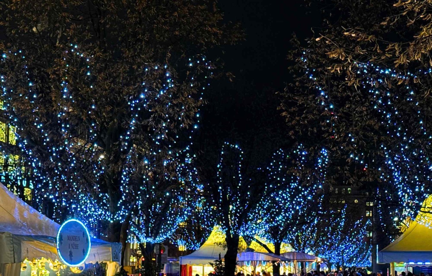 In the heart of Hamburg, the Jungfernstieg Christmas Market unfolds as the epitome of holiday enchantment. The market, known as "Weißer Zauber" or White Magic, casts a mesmerizing glow upon the Binnenalster, creating an unparalleled ambiance that defines the most beautiful Hamburg Xmas experience. As visitors step into this festive realm, the white tents stand as beacons, imparting a sense of wonder that lingers in the memory long after the holiday season fades.  The approximately 650-meter-long market invites guests to embark on a sensory journey, exploring the myriad offerings from exhibitors who contribute to the Xmas decor in Hamburg. The market becomes a tapestry of inspiration, where every stroll reveals treasures that reflect the city's distinctive holiday spirit. It is a place where the enchantment of the season is not just observed but fully embraced.  The Jungfernstieg Christmas Market is a celebration that transcends time, leaving an indelible mark on the soul. The magnificent Alster location, bathed in golden splendor, becomes the radiant heart of the festivities. The air carries the enchanting fragrances of mulled wine and cinnamon, creating a sensorial tapestry that accompanies every step along the boulevard. It is not merely a market; it is a haven for fine shopping opportunities, where the atmosphere is curated with an attractive program that elevates the holiday spirit.  Under the starry sky, the market offers the exhilarating coolness of ice-skating—a timeless activity that transforms the festivities into a captivating dance beneath the winter heavens. Arts and crafts enthusiasts find solace amidst stalls brimming with fantastic treasures, each item a testament to the boundless creativity of local artisans. As a special treat, five imaginatively decorated fairytale ships anchor in place, becoming whimsical sentinels that add an extra layer of wonder to the festive tableau.  In the pulsating heart of Hamburg, the Jungfernstieg Christmas Market transports visitors to a glittering winter landscape where tradition and modernity harmoniously coexist. The elegant white design becomes a canvas for the festive lights, and the picturesque location on the shores of the Binnenalster provides a backdrop that invites everyone to linger and savor the beauty of the season. This is not merely a market; it is an invitation to immerse oneself in the magic of Christmas—a celebration that captivates, inspires, and remains etched in the memory as the epitome of the most beautiful Hamburg Xmas.