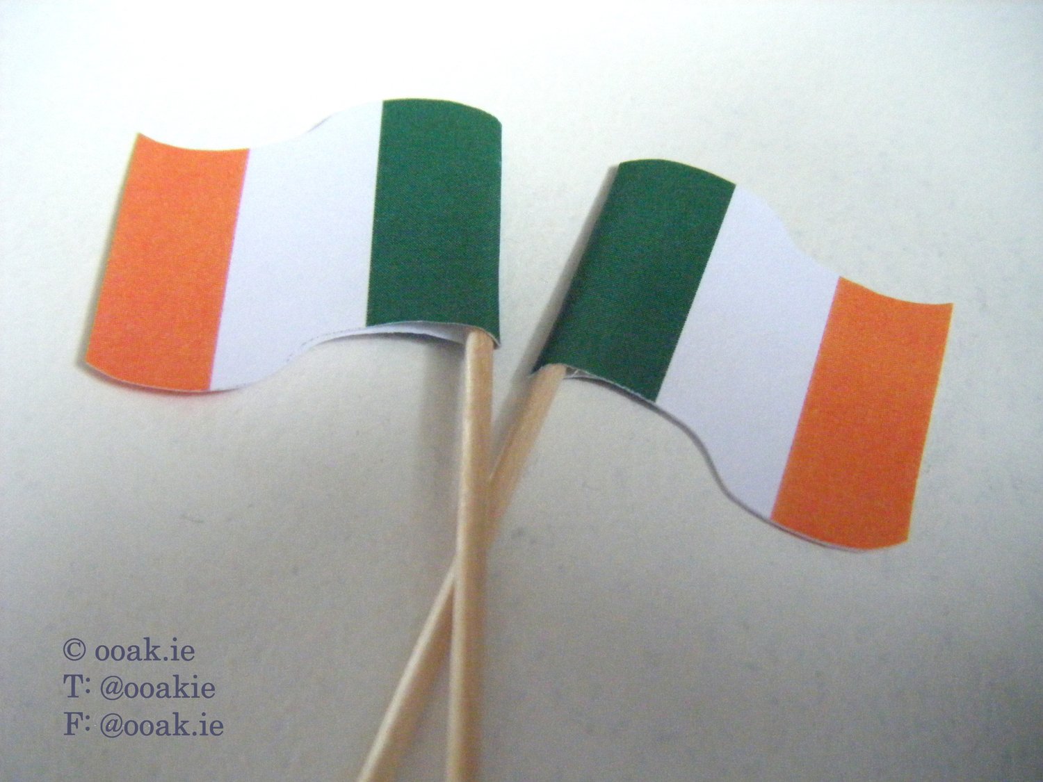 Sheet of printable mini Irish Tricolour flags in green, white, and gold for DIY St. Patricks Day cupcake toppers and food picks.
