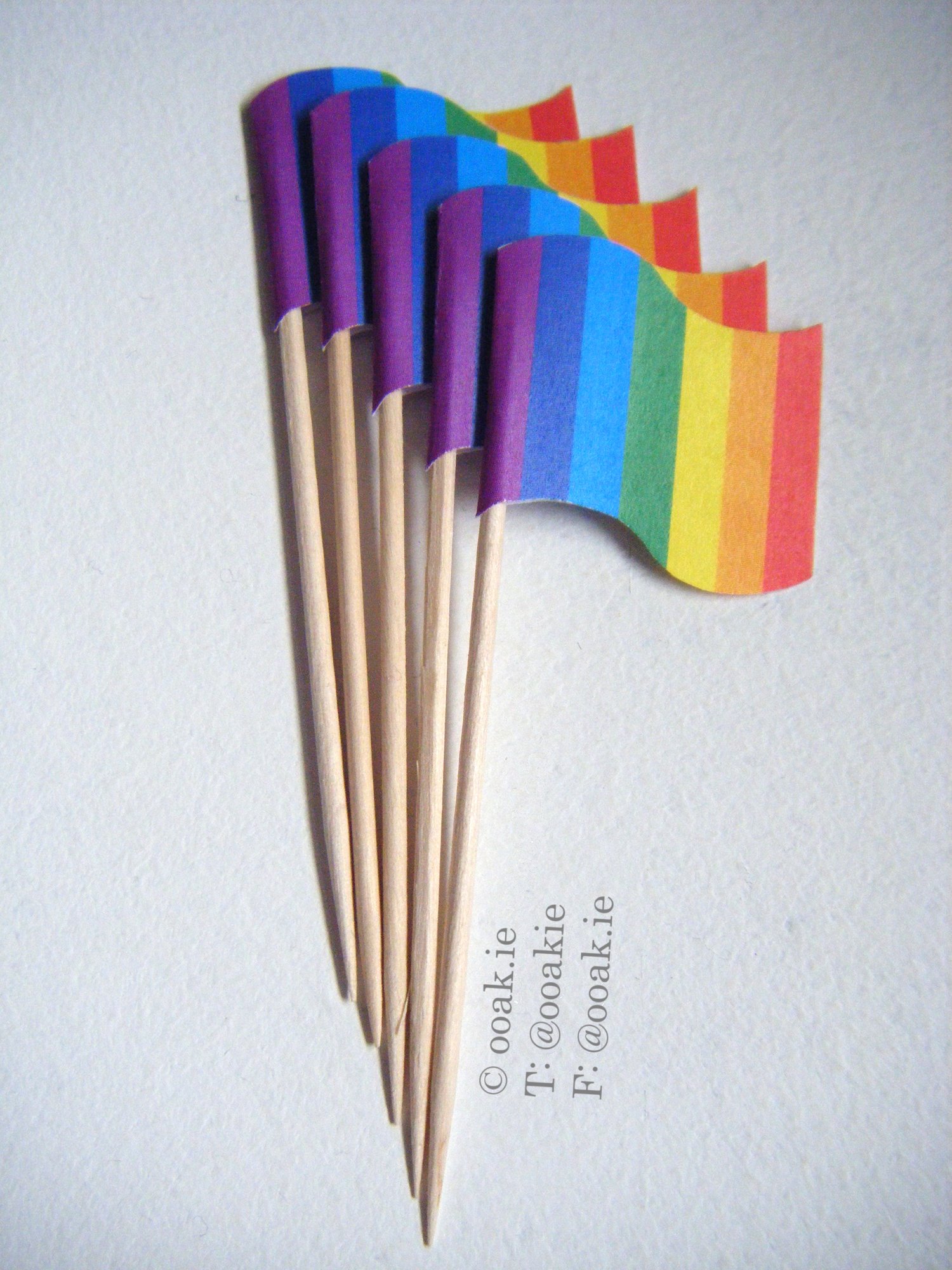Vibrant rainbow flag cupcake toppers for Pride, final product shown from a printable DIY paper craft kit.