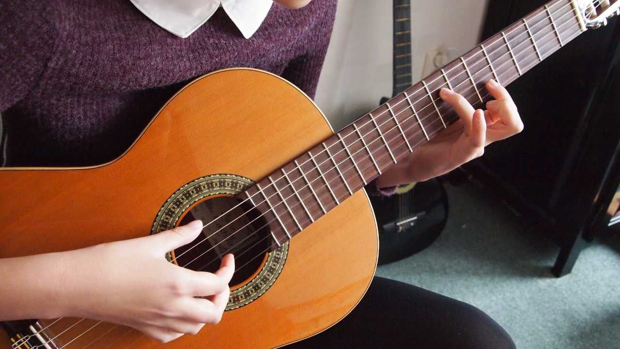 girls hands playing classical guitar