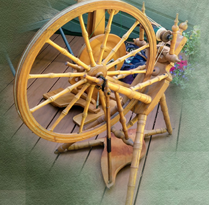 Antique spinning wheel on green background