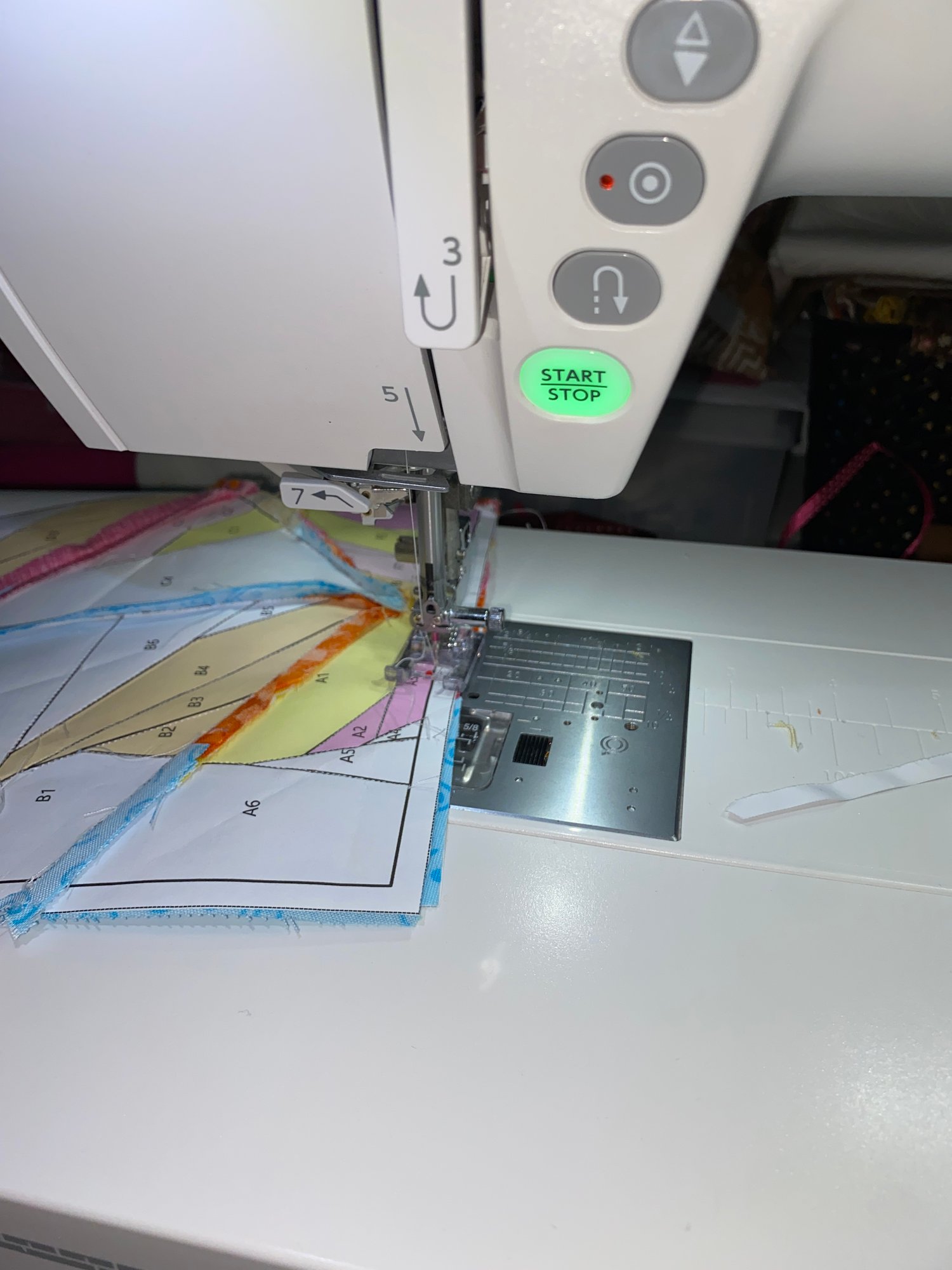 Tips for foundation paper piecing: Using the right needle can be a game changer in your quilting. This photo demonstrates the paper piecing process, sewing through a layer of paper and fabric.