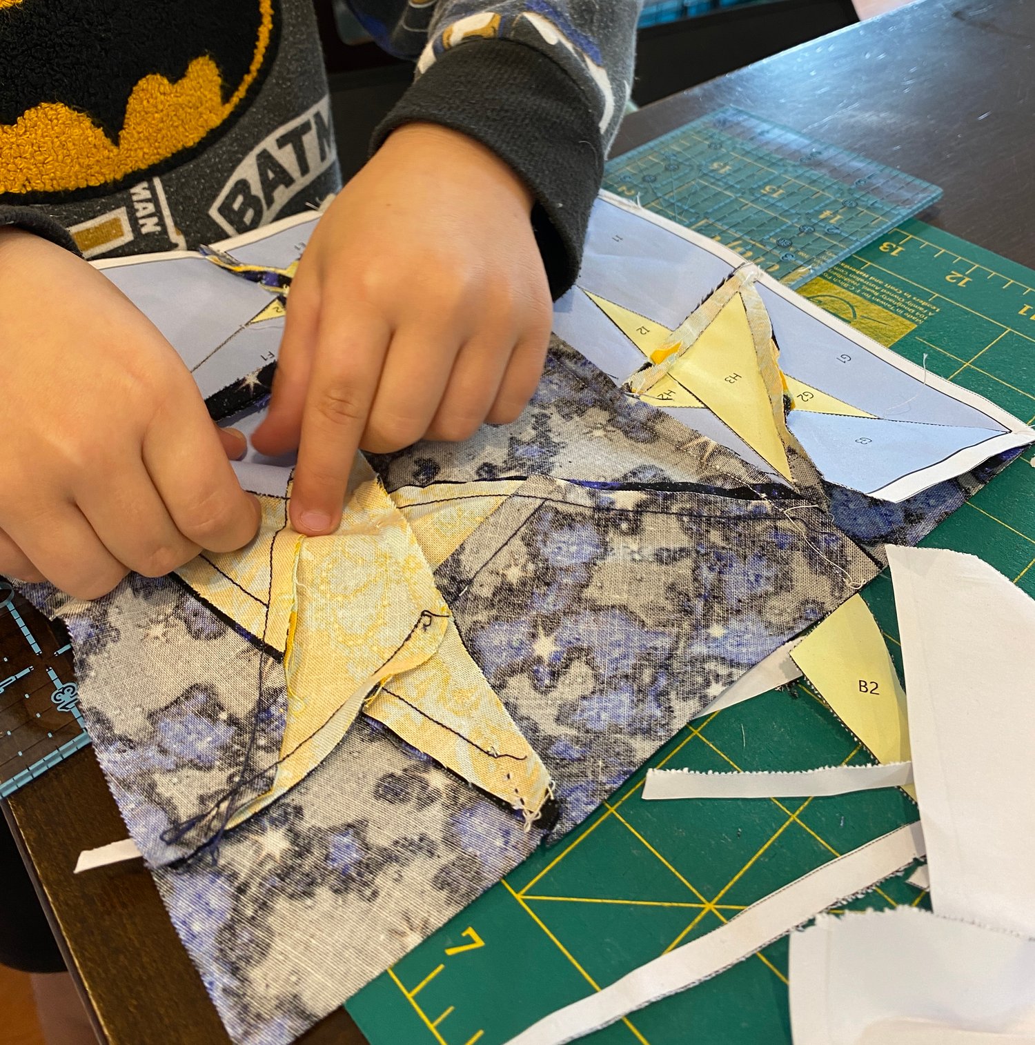 My six year old loves to help take the paper out of the back of paper pieced quilt blocks. Here he is ripping the paper out of a Star Quilt Block that I have sewn.
