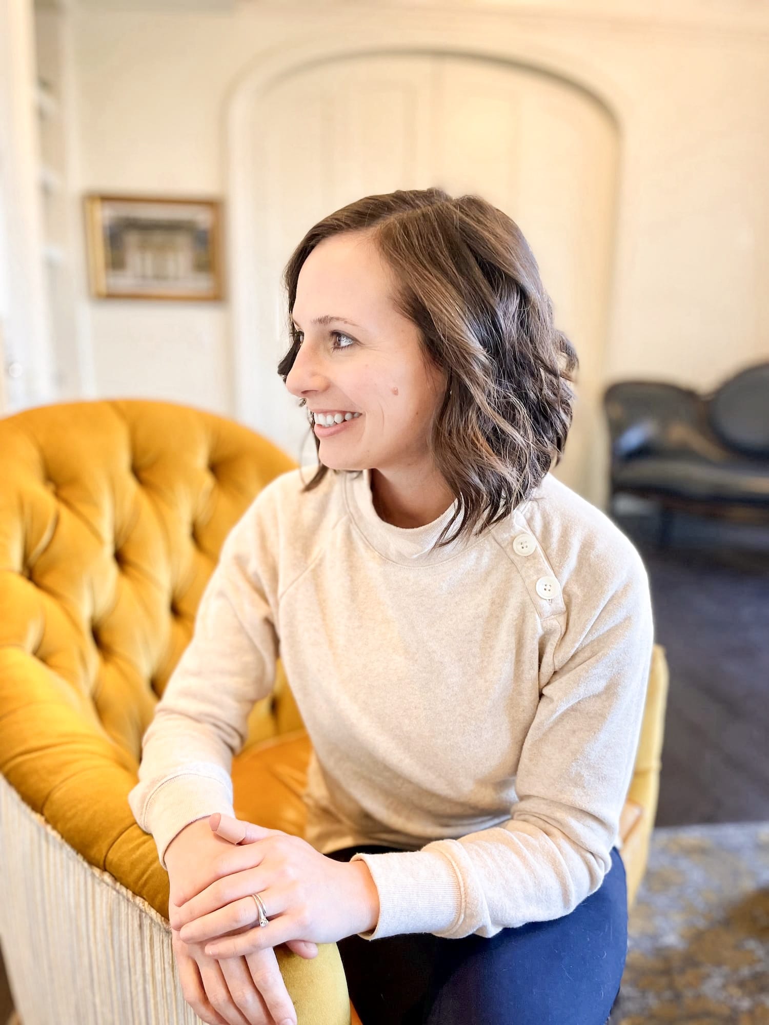 Ashley Danyew in gold upholstered chair, author of The Musicpreneur Model for self-employed musicians and music freelancers