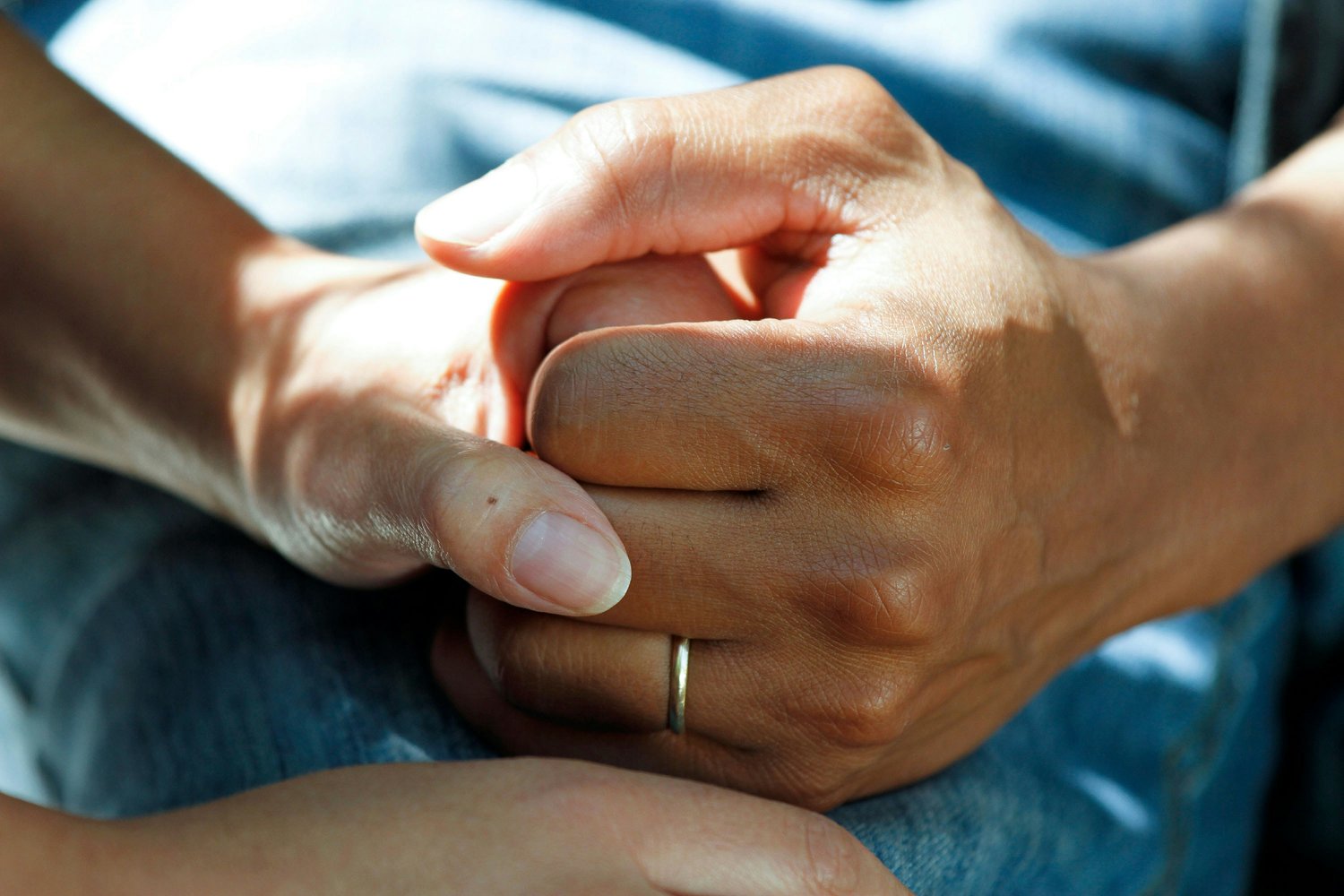 A middle-aged mother and her senior mother are holding hands, showcasing a tender moment of connection and support between generations.