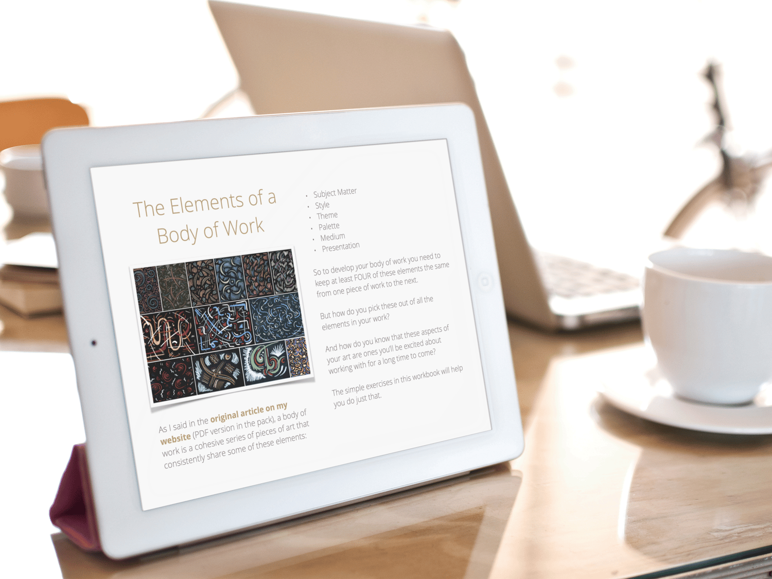 The Elements of a Body of Work - sample page displayed on propped up iPad with white cup and saucer and laptop in background.