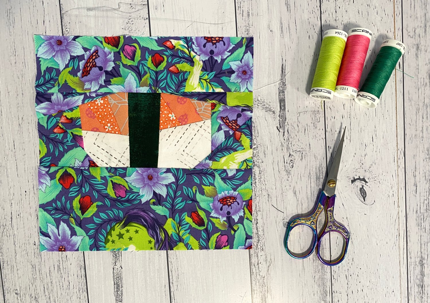 This Oshizushi Quilt block was made with a scrappy quilt method and uses Tula Pink fabric in the background.