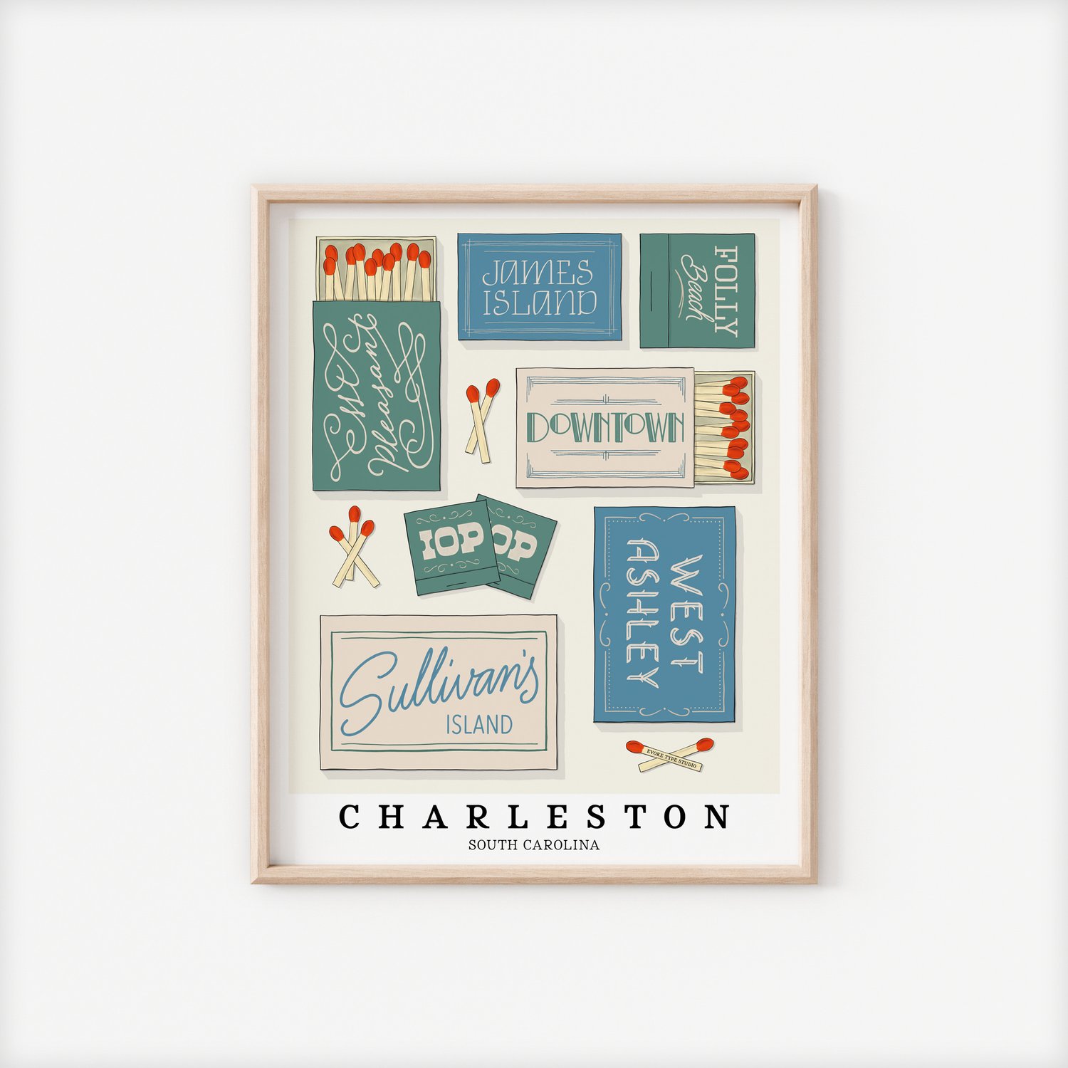 A framed picture of Charleston, South Carolina neighborhoods drawn in various lettering styles on matchboxes. Artwork has a coastal color scheme of blue, green and beige.