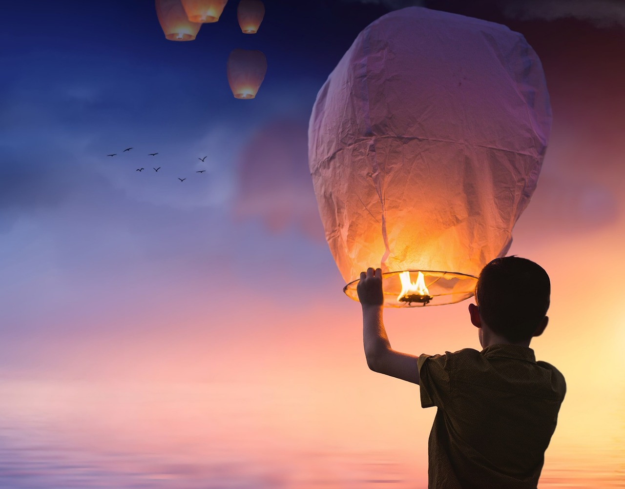 Globo, farolillos chinos y fondo libre-chico con camiseta gris sujetando un globo durante el atardecer-luz y oscuridad