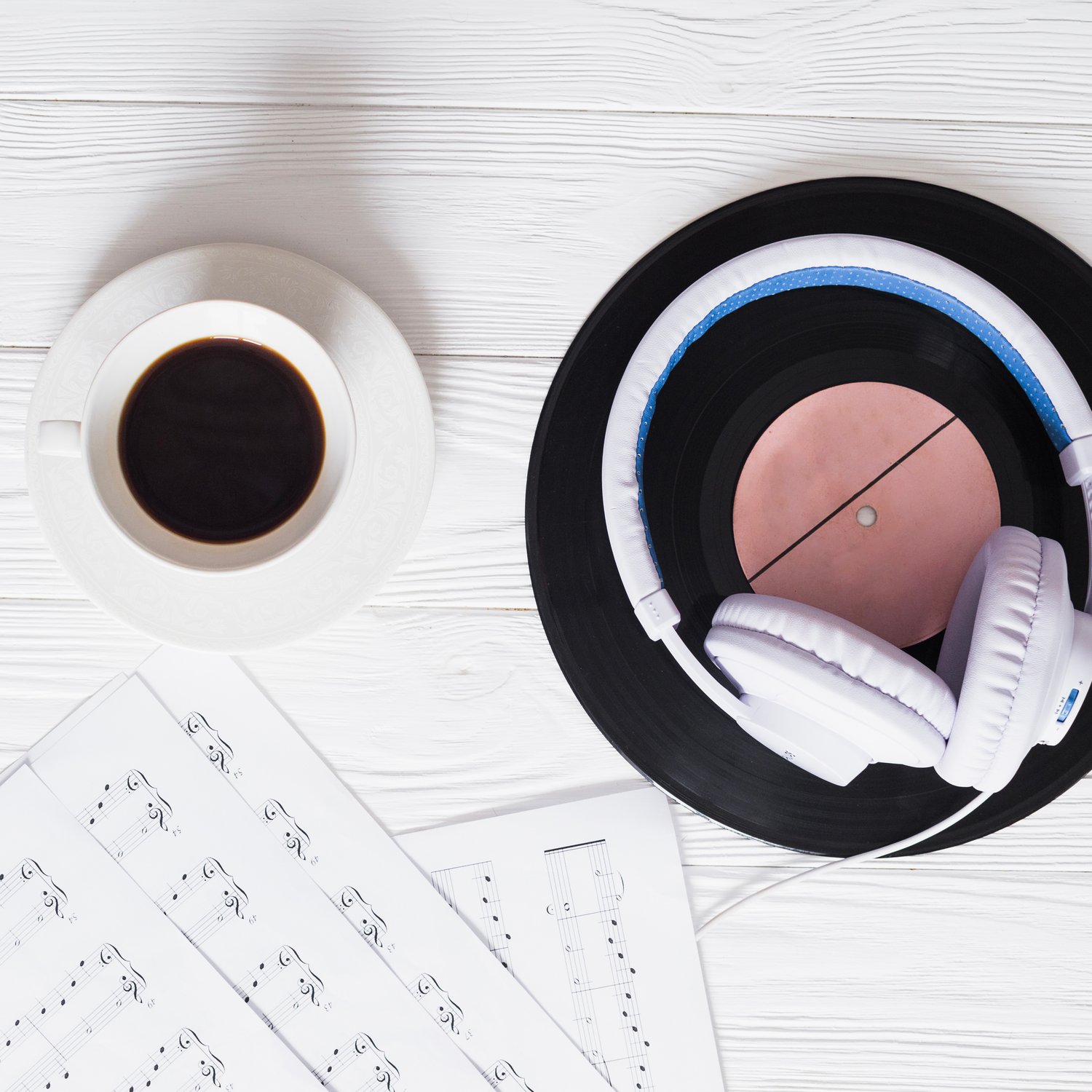 Foto de partituras-taza de café-auriculares blancos-alfombrilla con forma de vinilo negra y rosa