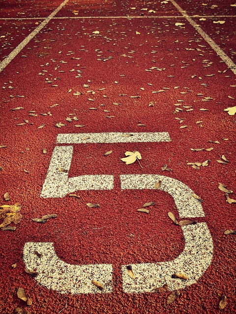 Foto campo de deportes, pista roja y número cinco