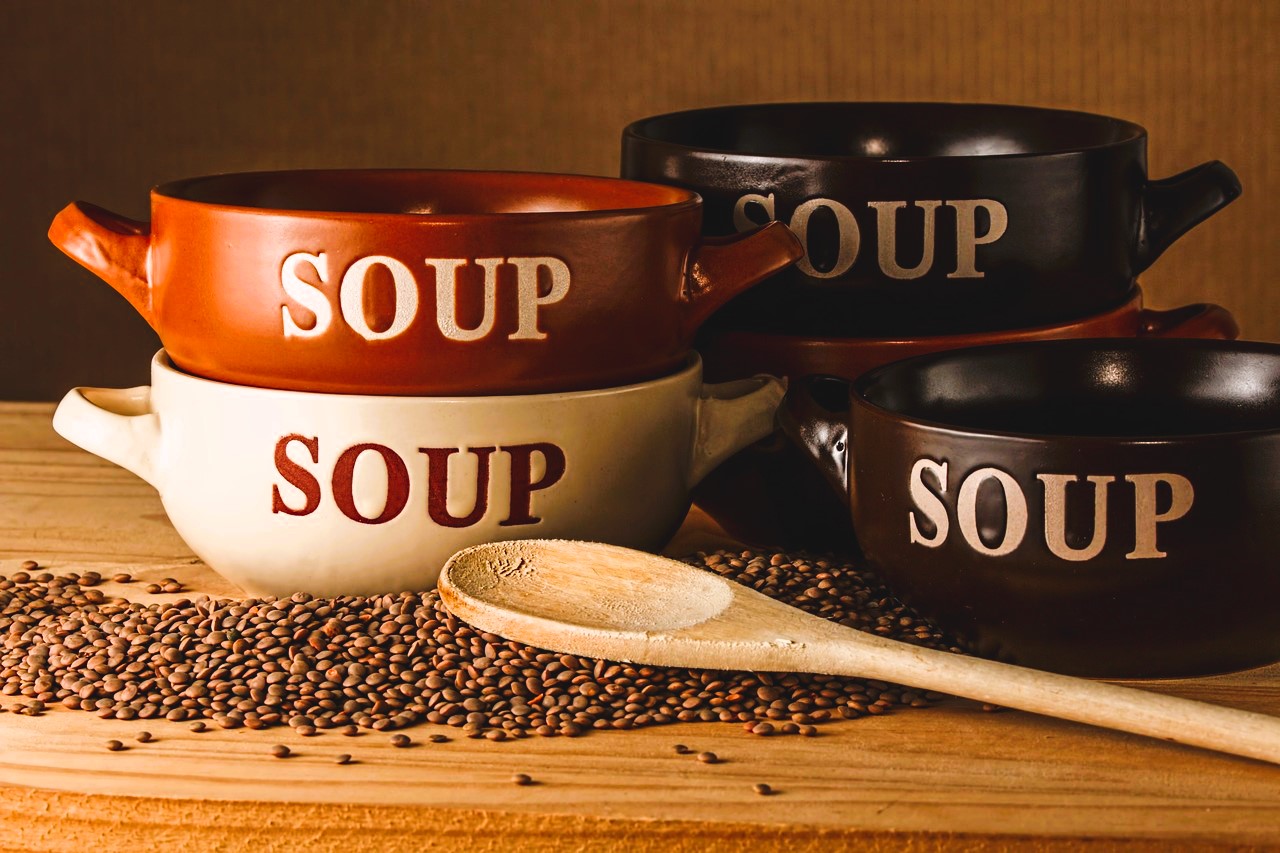 Tazón de sopa, lentejas y cuchara de palo