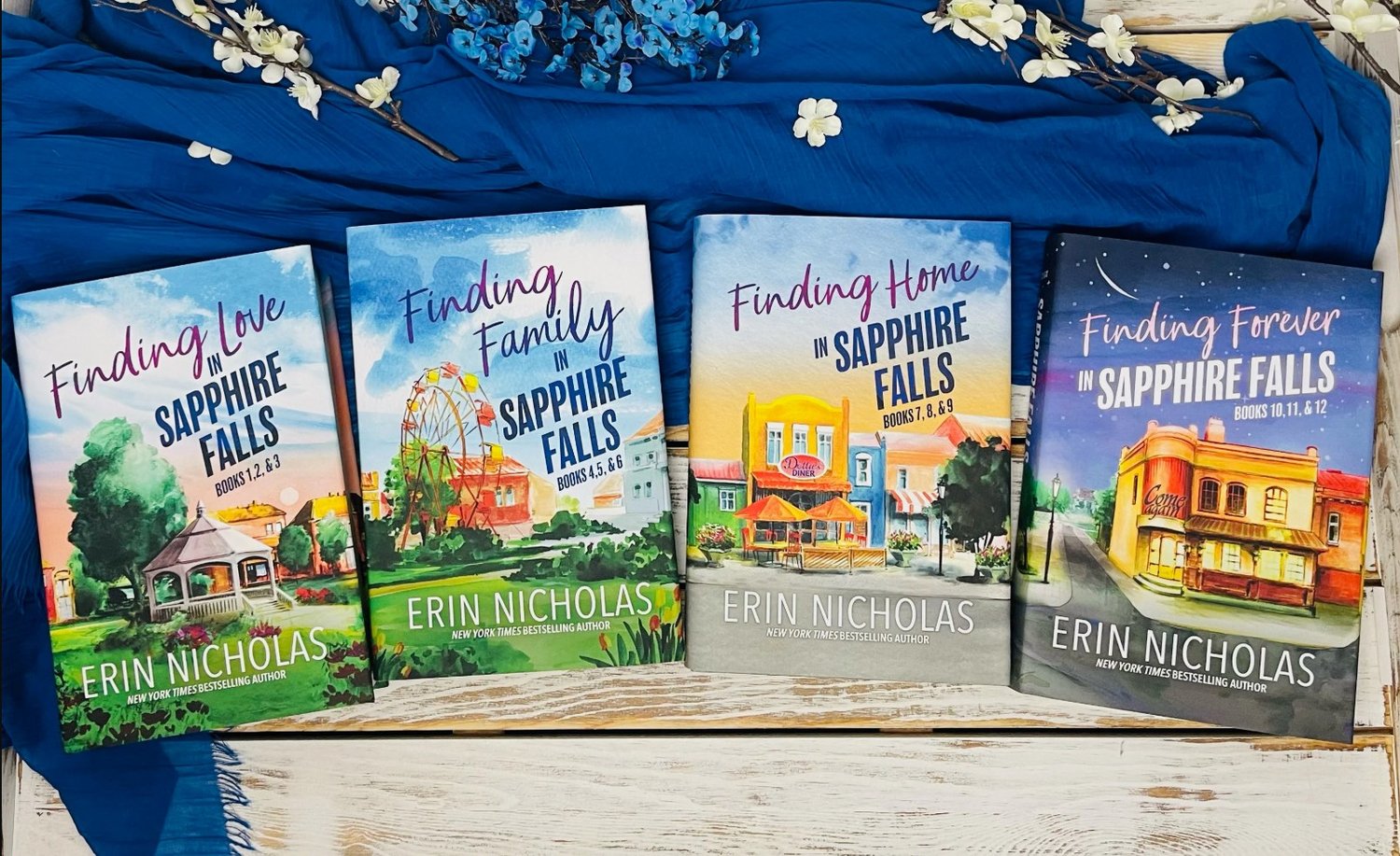 Covers of hardback Sapphire Falls special edition books 1-12, split into 4 volumes