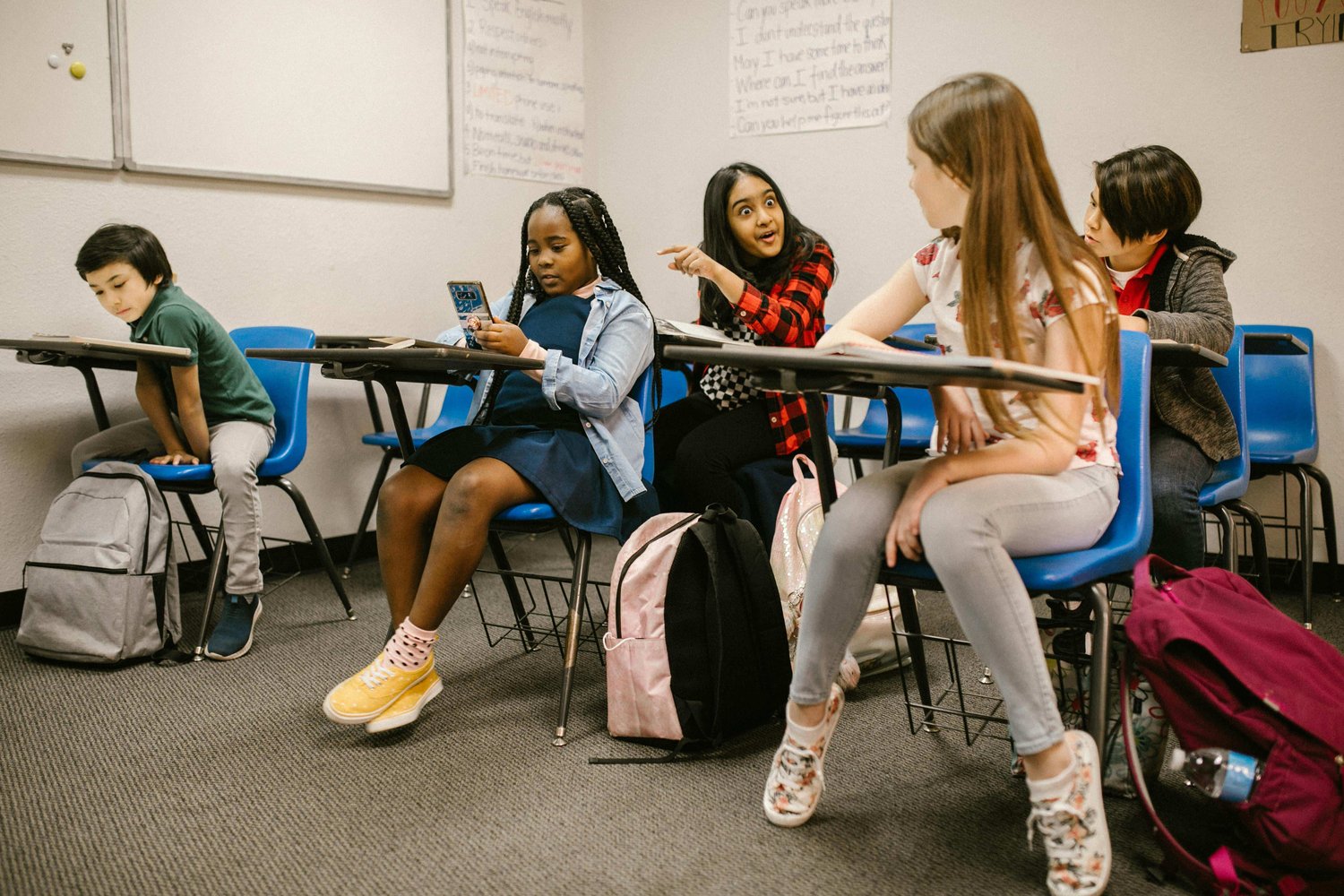 classroom bully pointing towards another classmate