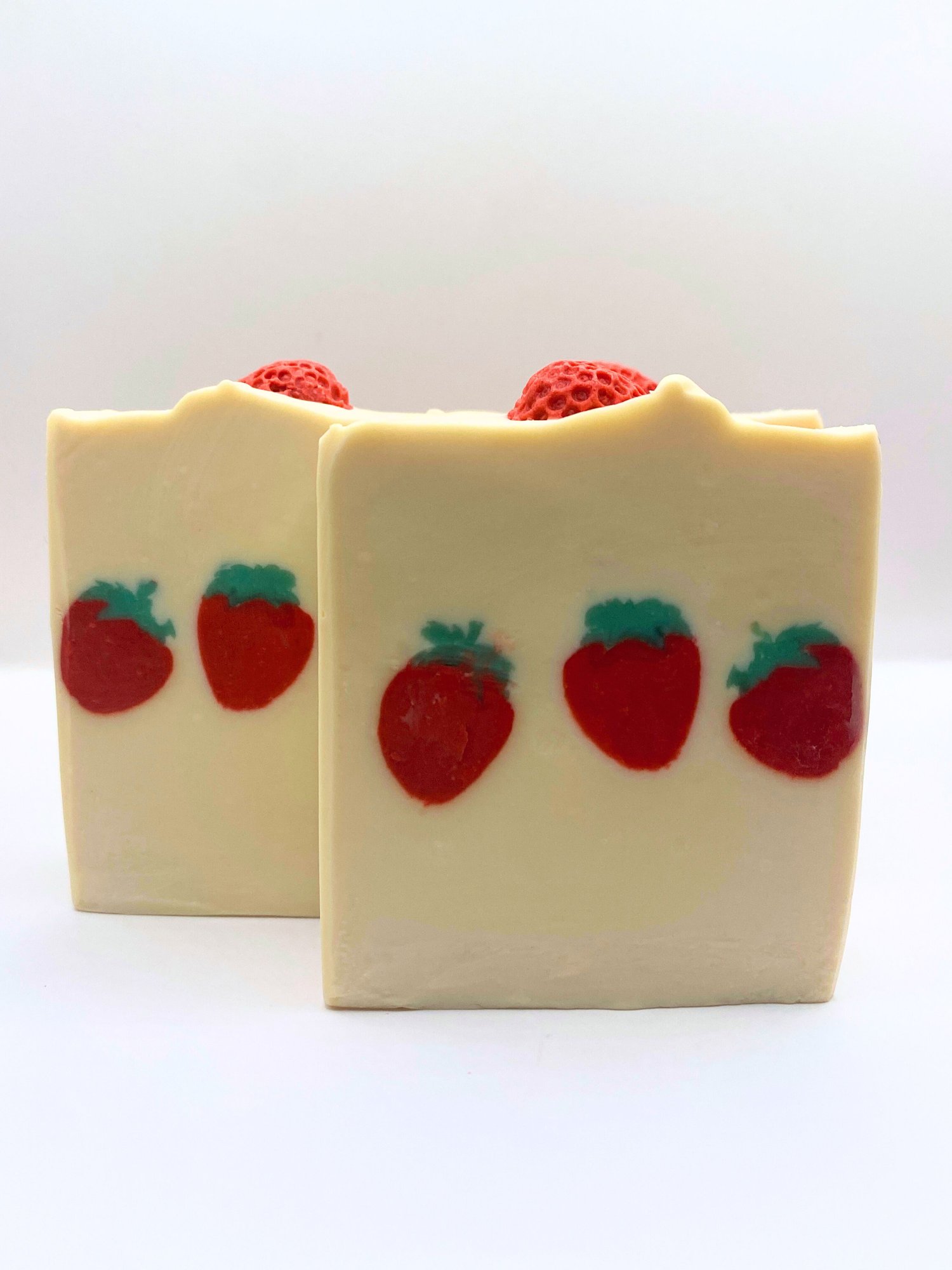 U-Pick Strawberry handmade soap smells like berries. The design features three strawberries through the middle of the soap and another strawberry sits on top