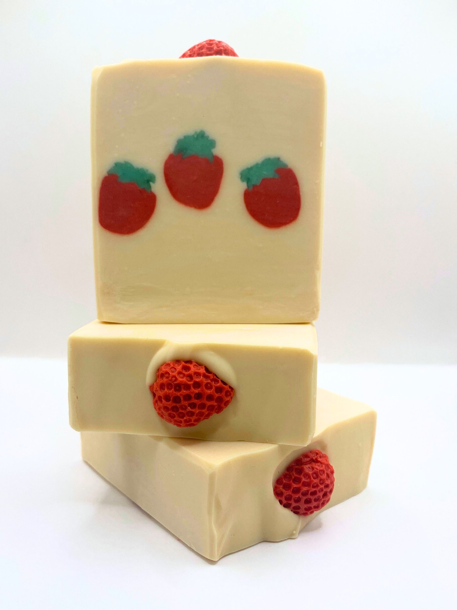 U-Pick Strawberry handmade soap smells like berries. The design features three strawberries through the middle of the soap and another strawberry sits on top