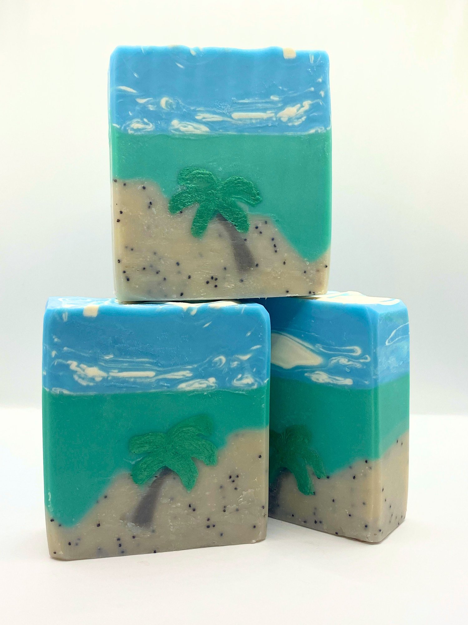 Three bars of handmade Palm Beach soap depicting a palm tree on a beach