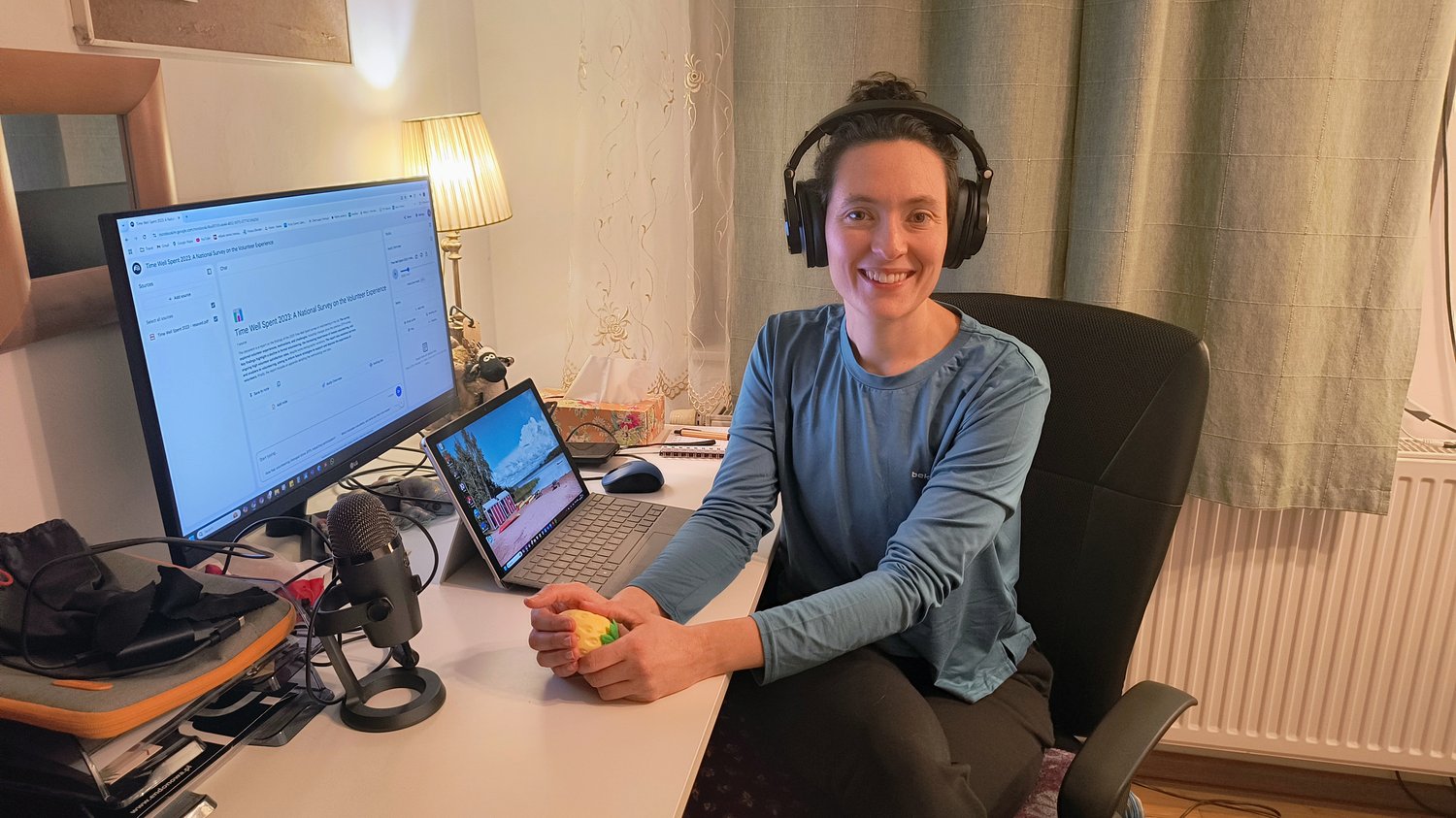 A woman wearing headphones, sitting at a desk