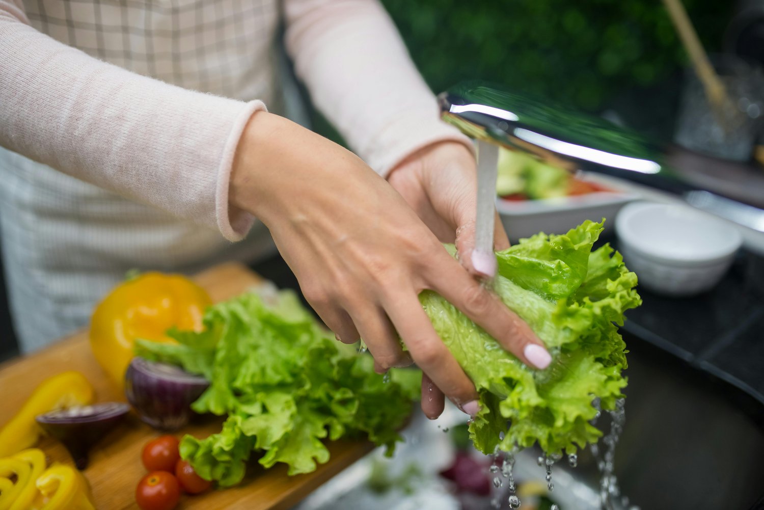 Washing vegetables under a running tap