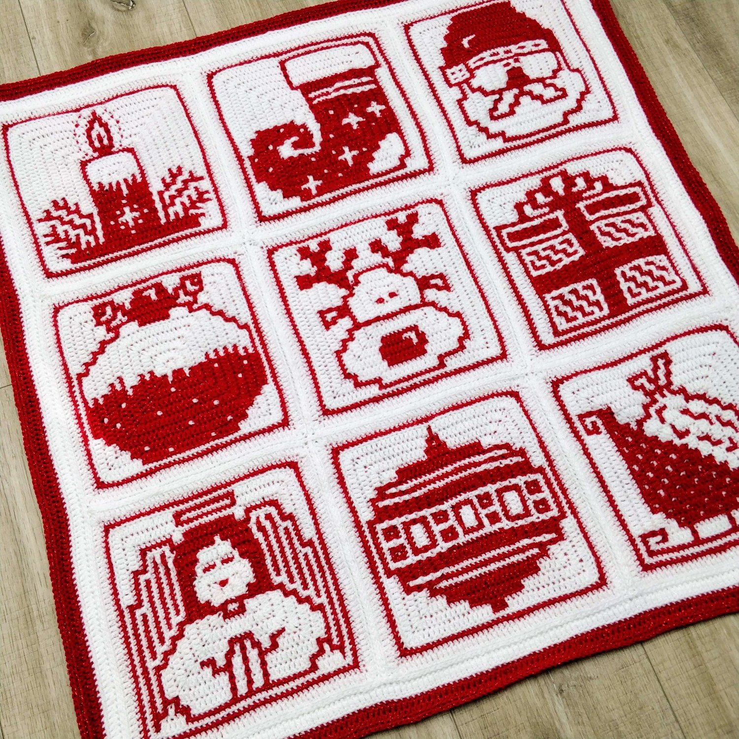 Nine Christmas motifs laid out in a three by three square blanket made in red and white