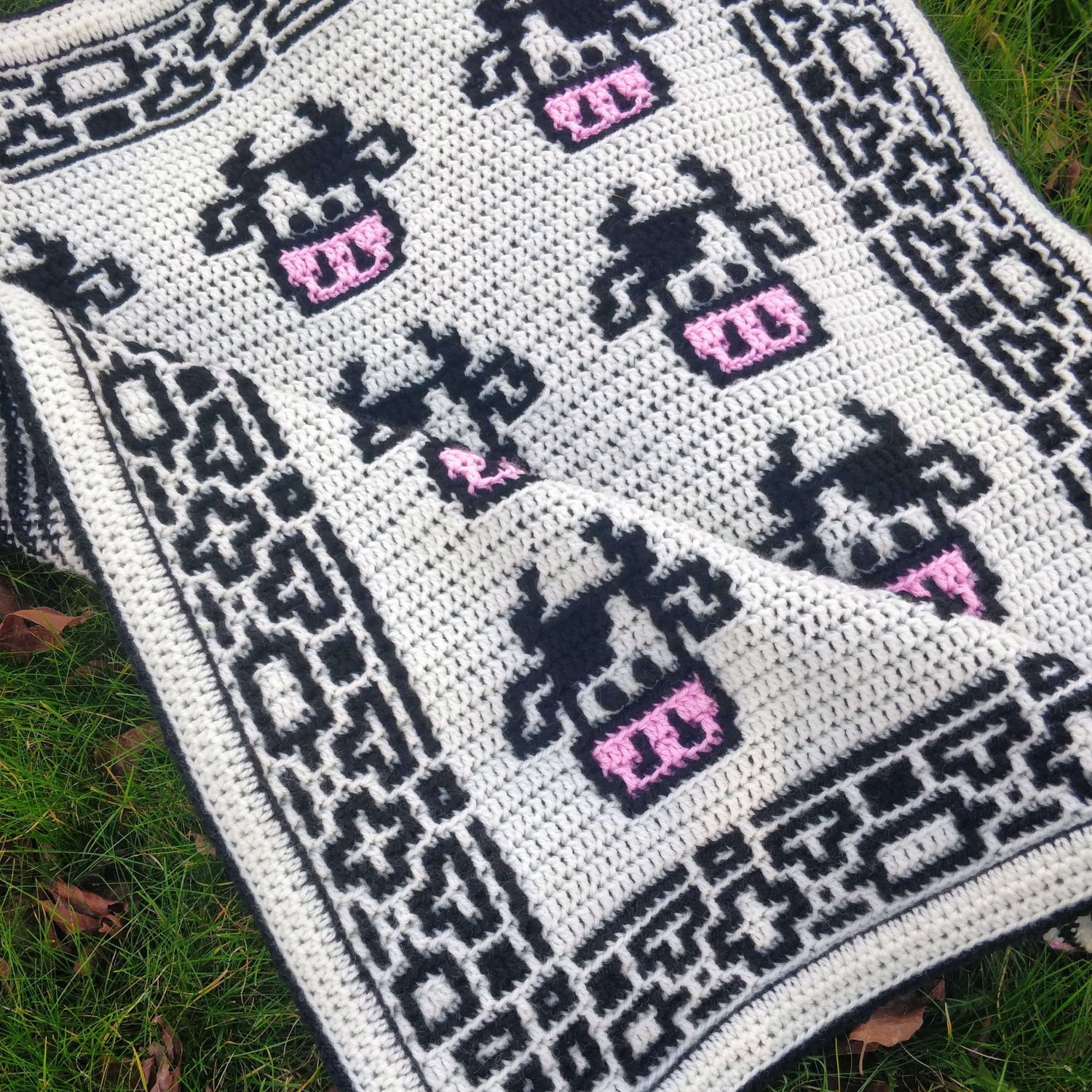 Crochet blanket covered in cute cow faces with pink noses