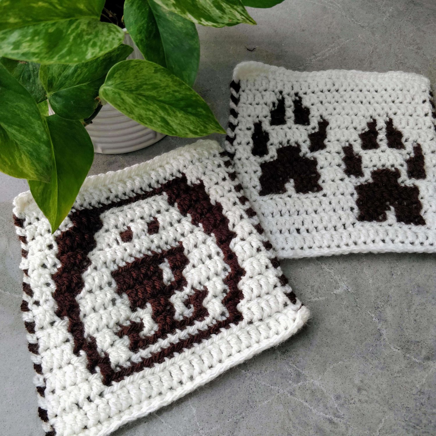 Crochet square motifs showing a dogs face and dog paw prints