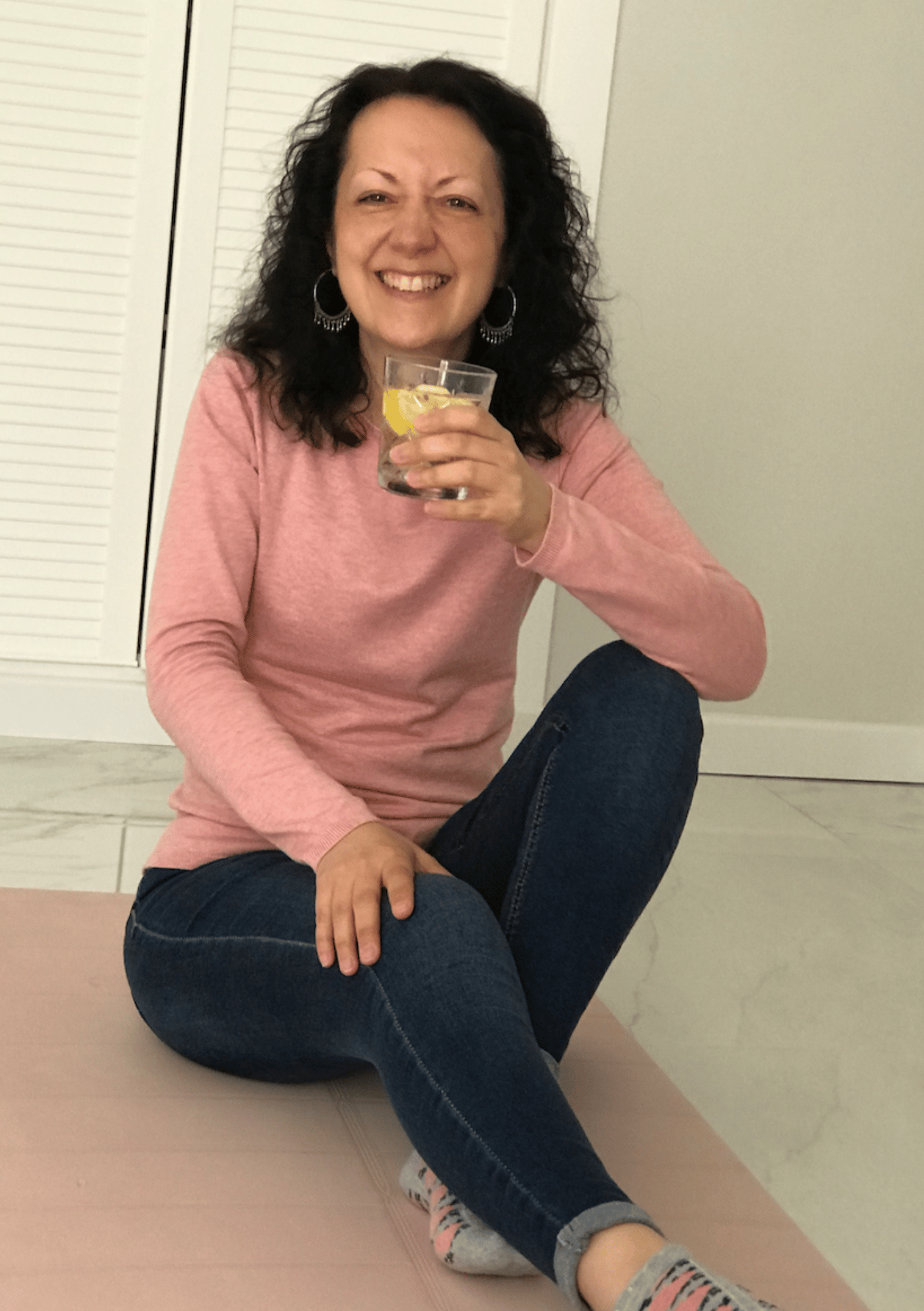 Isabel Bar smiling while holding a lemon water – intuitive guide and holistic wellness mentor for soul-led women - home page of iamisabelbar.com